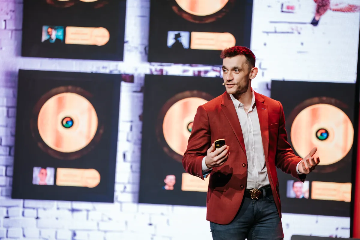 Julian on stage in front of YouTube Play Buttons wall